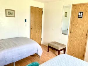 a bedroom with two beds and a door with a stool at Near Yellowstone Park and Chico Hot Springs in Emigrant