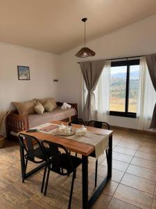 a living room with a table and a couch at Crisálida Cabañas Villa Yacanto in Villa Yacanto