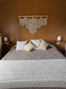 a bedroom with a large bed with white pillows at Crisálida Cabañas Villa Yacanto in Villa Yacanto