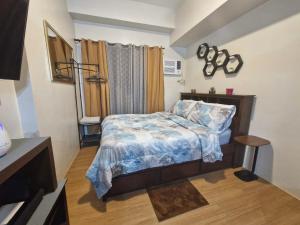 a small bedroom with a bed and a television at The Loop Towers Limketkai in Pontud