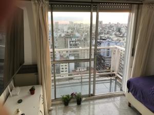 a bedroom with a large window with a view of a city at Corrientes Center in Buenos Aires