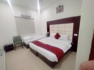 a bedroom with a large bed with a red blanket at Tira Hotel and Cafe in Rudraprayāg
