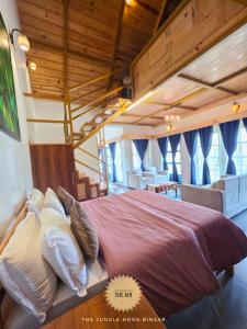 a bedroom with a large bed in a room with wooden ceilings at The Jungle Hook Binsar in Almora