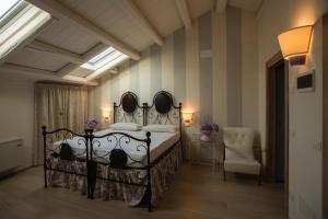 a bedroom with a bed and a chair at Dormire alla Ruota in Negrar