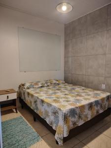 a bedroom with a bed and a table in it at Condomínio Central Meu Cantinho in Uruguaiana