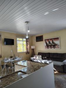 a living room with a couch and a table at Condomínio Central Meu Cantinho in Uruguaiana