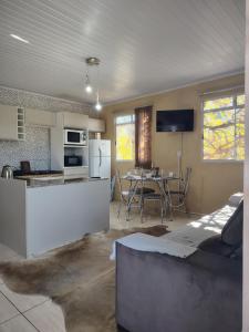 a kitchen and a living room with a table at Condomínio Central Meu Cantinho in Uruguaiana