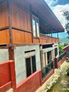 a building with a balcony with a dog in front of it at Pong Elak 'Guest House in Rantepao