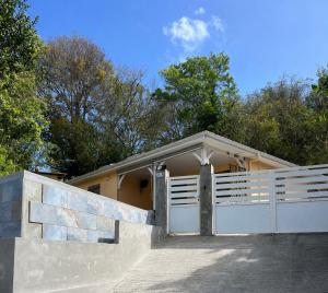 a house with a white fence and a garage at Villa Tidodo in Les Anses-dʼArlets