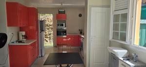a kitchen with red cabinets and a black table at Villa Tidodo in Les Anses-dʼArlets