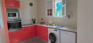 a kitchen with red cabinets and a washing machine at Villa Tidodo in Les Anses-dʼArlets +9 photos