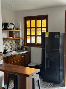 a kitchen with a black refrigerator and a table at Apartamento acogedor cerca al parque con balcón in Jardin