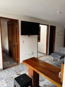 a living room with a table and a flat screen tv at Apartamento acogedor cerca al parque con balcón in Jardin