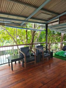 a porch with chairs and a table on a deck at Monkey House Hostel & Guest House Koh Samui in Chaweng Noi Beach