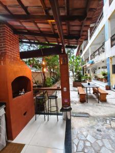 a patio with a brick fireplace and tables and chairs at Pousada Ilha do sol in Piúma +9 photos