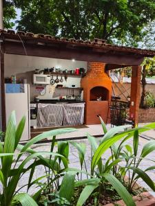 an outdoor kitchen with a counter and a oven at Pousada Ilha do sol in Piúma