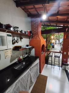 a kitchen with a sink and a microwave at Pousada Ilha do sol in Piúma