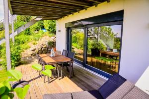 a patio with a table and chairs on a deck at Anja's Ferienwohnung Europa Park in Ettenheim