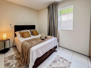 a bedroom with a bed and a window at Centro, apê 2 Quartos com Ar | Garagem in Brusque