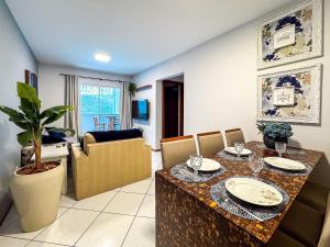 a living room with a table and a dining room at Centro, apê 2 Quartos com Ar | Garagem in Brusque