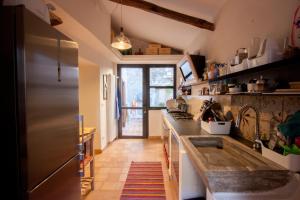 cocina con fregadero y nevera en Lelive Bed and Breakfast, en Sermoneta