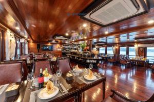 a restaurant on a train with tables and chairs at Aqua Elegance Cruise - Halong Bay by AHG in Ha Long