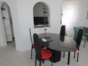 ein Esszimmer mit einem schwarzen Tisch und Stühlen in der Unterkunft Residenz al Parco in Ascona