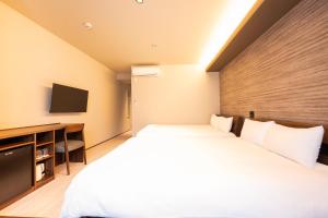 a hotel room with a bed and a tv at WANOKAEDE HOTEL New Wing in Tokyo
