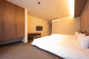 a bedroom with a large white bed and a cabinet at WANOKAEDE HOTEL New Wing in Tokyo