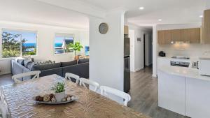 a kitchen and living room with a table and chairs at Aqua Breeze by Experience Jervis Bay in Vincentia