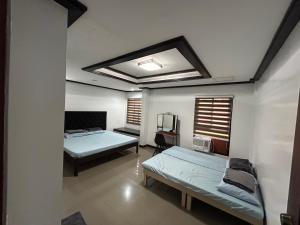 a room with two beds in it with a ceiling at MG Holiday Home Tagaytay in Tagaytay