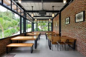 a restaurant with wooden tables and chairs and windows at Seacrest Boutique Kohtao Thailand in Ko Tao