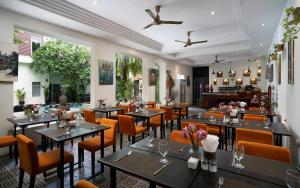 a restaurant with tables and chairs and a bar at Boutique Indochine d'Angkor in Siem Reap