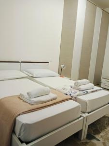 a room with three beds with towels on them at Aaron guest house 1 in Marghera +17 photos
