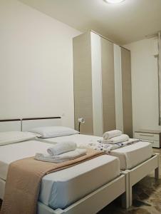 a room with three beds and a mirror at Aaron guest house 1 in Marghera