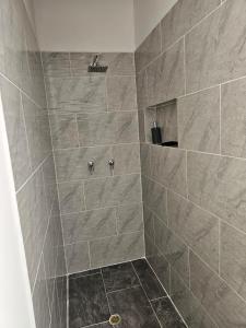 a bathroom with a large shower with gray tiles at Casa luz in Medellín +32 photos