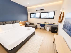 a bedroom with a bed and a couch and a table at De Botan Bangna in Bangkok