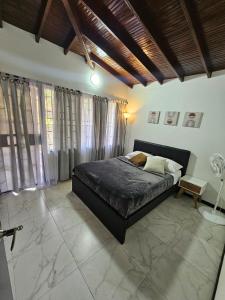 a bedroom with a bed in a room with windows at Casa luz in Medellín