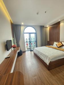 a bedroom with a large bed and a large window at Sunrise Hotel Tại Sầm Sơn in Thanh Hóa