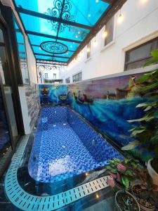 a swimming pool in a building with a painting on the wall at Sunrise Hotel Tại Sầm Sơn in Thanh Hóa