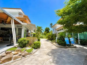 a house with two blue chairs next to a driveway at Field-D House in Ko Tao