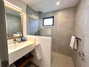 a bathroom with a sink and a mirror at Eastern Blue Beachfront Apartment in Poste Lafayette