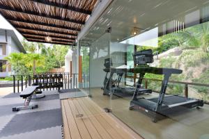 a gym with glass walls and a treadmill and exercise equipment at Seacrest Boutique Kohtao Thailand in Ko Tao