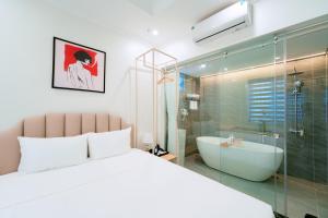 a bedroom with a white bed and a bath tub at Nhật Tân Hotel Triển Lãm VEC - Đông Anh in Dong Anh +80 photos