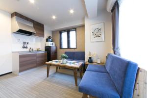a living room with a blue couch and a table at AI Annex in Osaka
