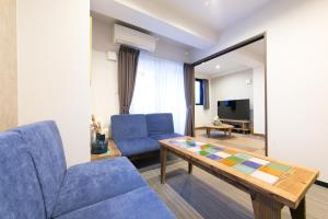 a living room with a blue couch and a table at AI Annex in Osaka