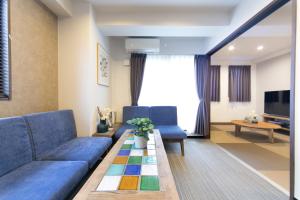 a living room with a blue couch and a table at AI Annex in Osaka