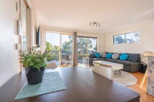 a living room with a table and a couch at Bay View Escape in Binalong Bay