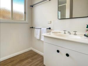 a white bathroom with a sink and a mirror at Bay View Escape in Binalong Bay +60 photos