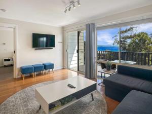 a living room with a couch and a view of the ocean at Bay View Escape in Binalong Bay
